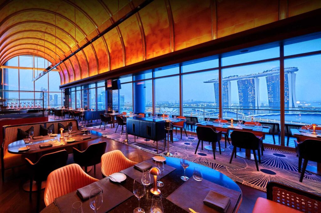 Luxurious dining room with with elegant furniture, ambient lighting, and skyline view of Marina Bay Sands.