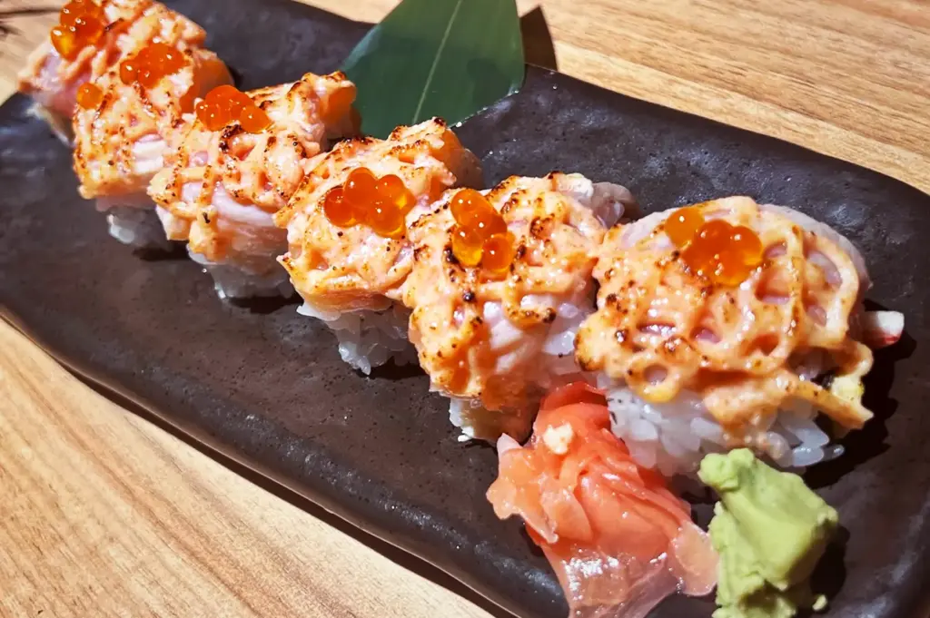 Aburi mentaiko sushi rolls topped with seared spicy cod roe mayo and ikura salmon roe, served with ginger and wasabi at Niningashi Japanese Izakaya restaurant.