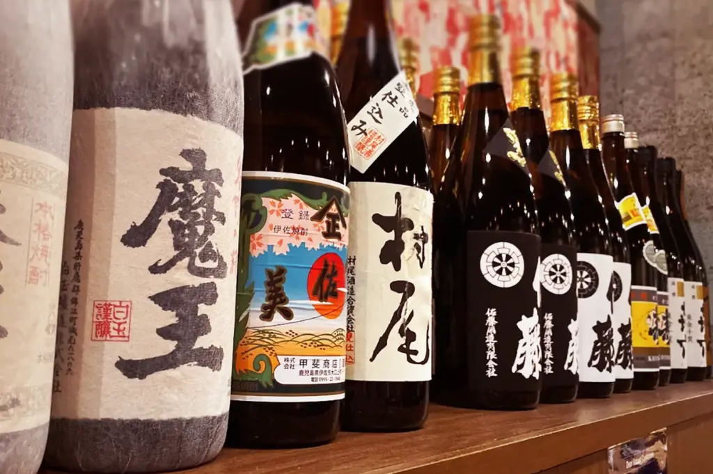Premium selection of authentic Japanese sake and shochu bottles with traditional Kanji labels on display at Niningashi Japanese Izakaya restaurant.