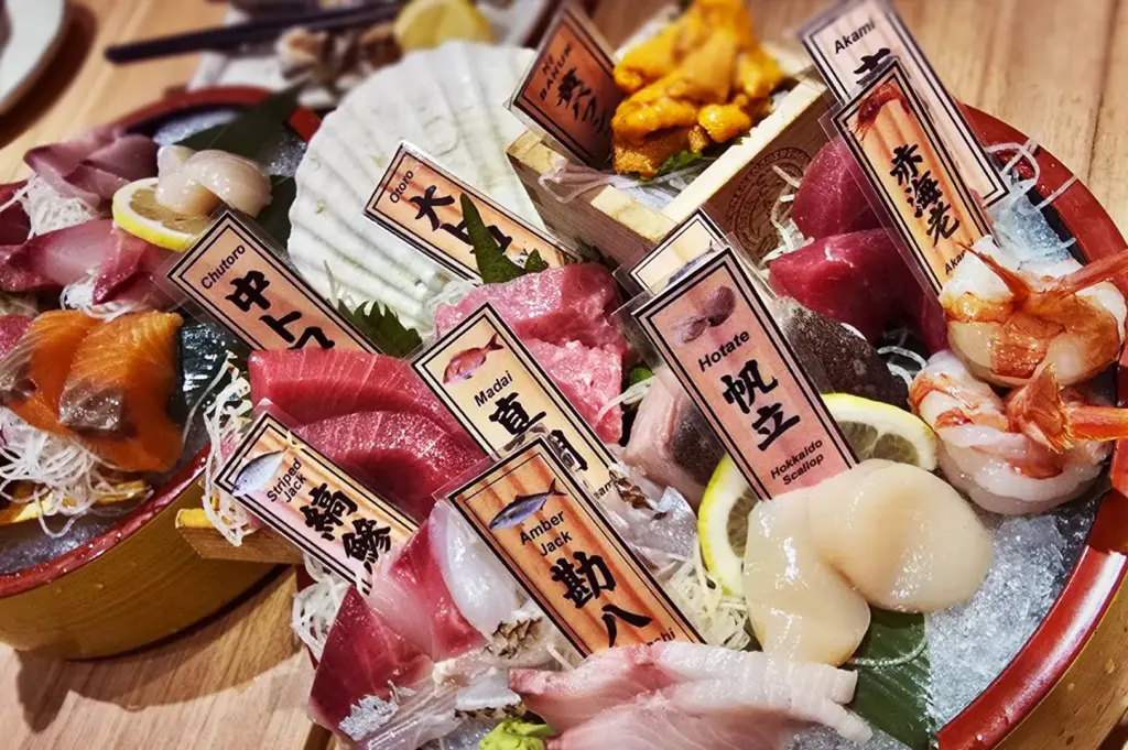 Premium Japanese chef's selection sashimi platter at Niningashi Izakaya, featuring Uni sea urchin, Chutoro and Otoro tuna, Hotate scallops, and Amber Jack.