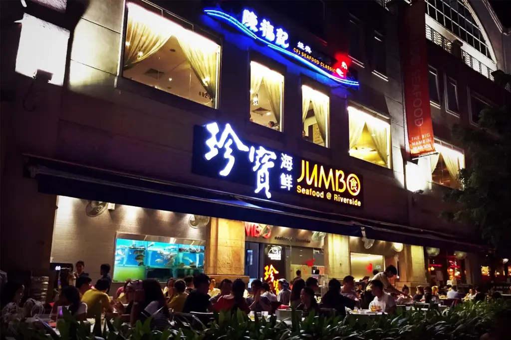 Vibrant exterior of JUMBO Seafood at Riverside Point, Clarke Quay, featuring illuminated signage and outdoor dining at night.
