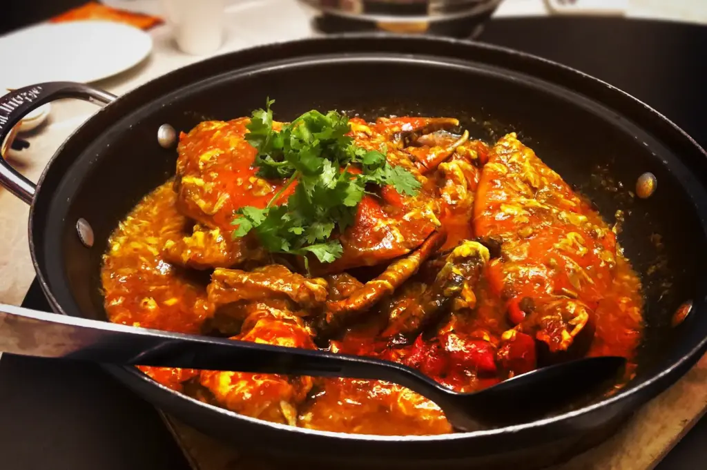 Signature JUMBO Seafood Singapore chili crab dish served in a hot pan, topped with fresh coriander.