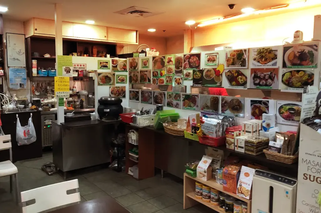 Interior of New Green Pasture Cafe showing a cozy seating area to wait and eat and walls decorated with pictures of the vegetarian menu.