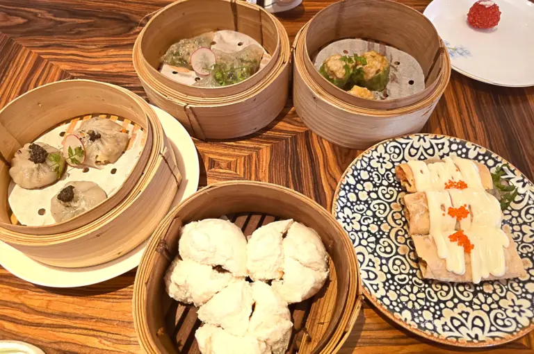A premium spread of assorted dim sum, including bamboo steamers with dumplings and crispy appetizers, perfect for a traditional Chinese dining experience of Sichuan and Cantonese cuisines in Singapore.