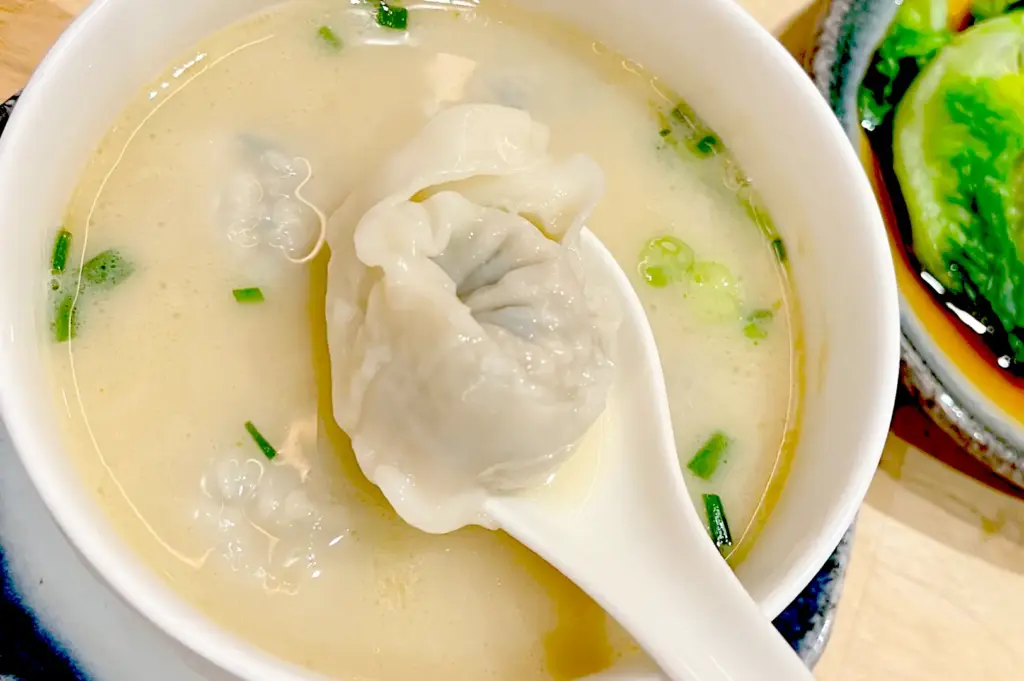 A bowl of comforting pork bone broth soup at LeNu Chef Wai's Noodle Bar, served with plump, freshly prepared dumplings.