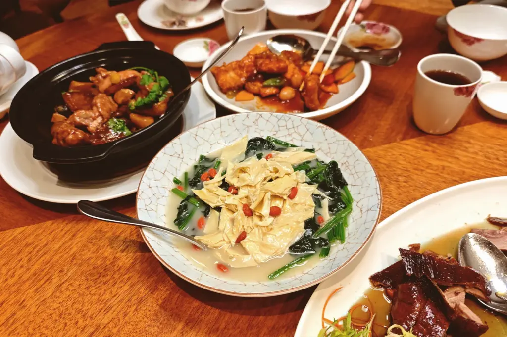 A gourmet selection of Chinese dishes including stir-fried vegetables with beancurd skin and braised meats at Xin Cuisine at Holiday Inn Singapore Atrium.
