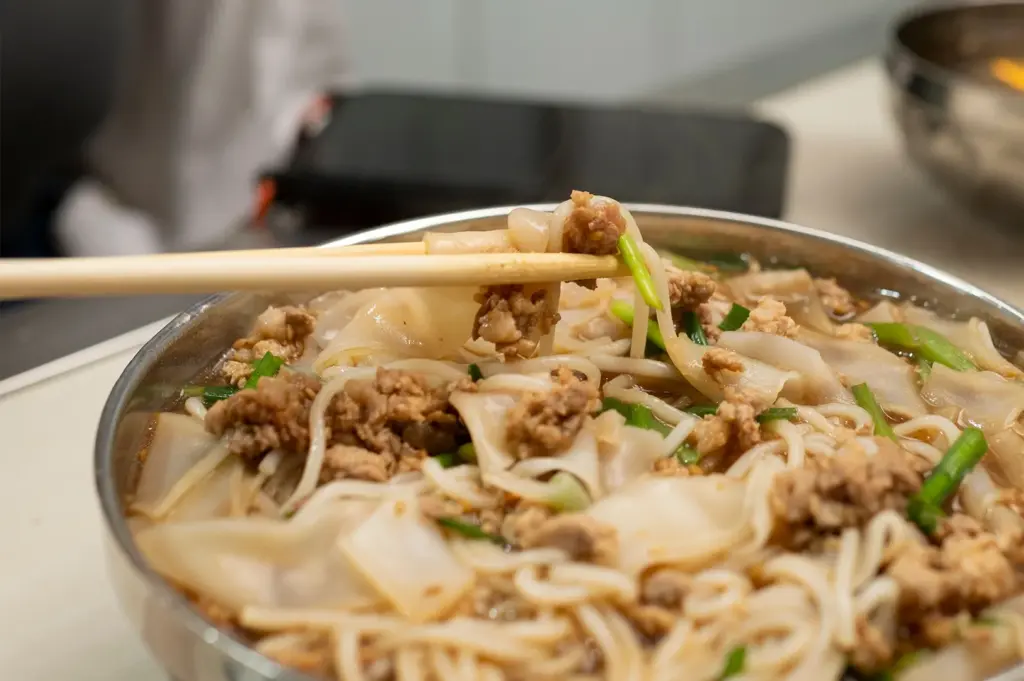 A bowl of hearty noodles from the wheat family, highlighting the firm, springy texture and versatility of wheat-based dough in Chinese culinary traditions.