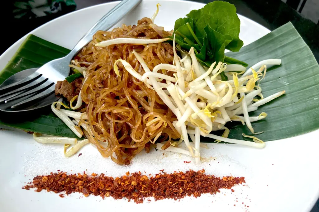 A beautifully plated dish of starch-based noodles served on a banana leaf with bean sprouts and chili powder, representing the wide variety of noodles derived from various starches.