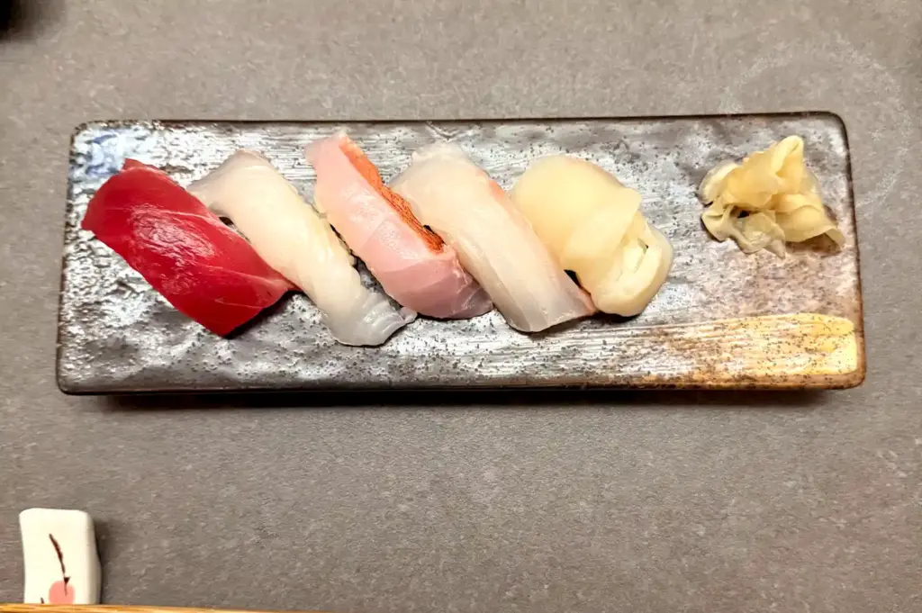 A traditional assortment of premium nigiri sushi served on a textured ceramic plate at Ganko Sushi Singapore.