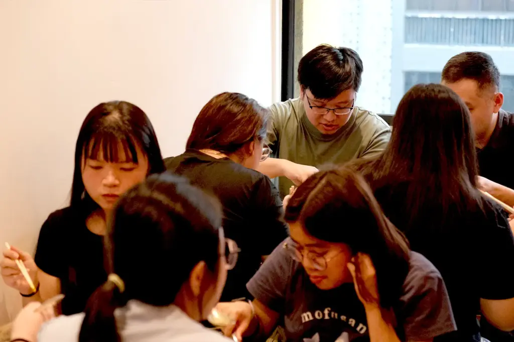 A group of customers focused on eating and enjoying their meals together inside the cozy, warm-lit dining area of Soup Curry by Ki-setsu.