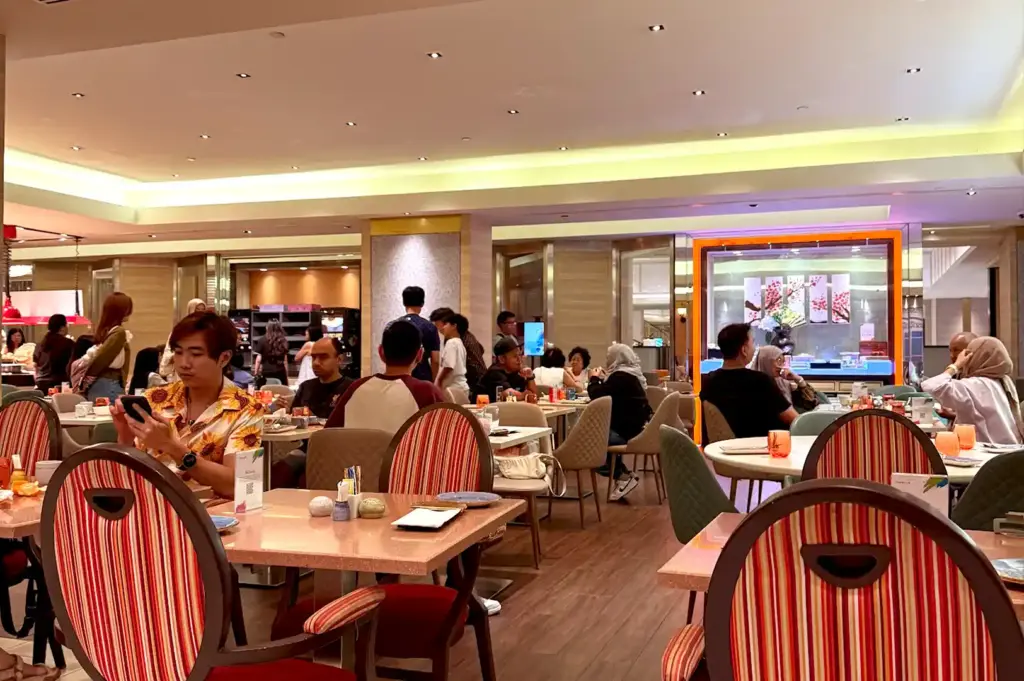 Spacious, brightly lit dining area filled with guests at Carousel, a popular halal-certified hotel buffet in Singapore.