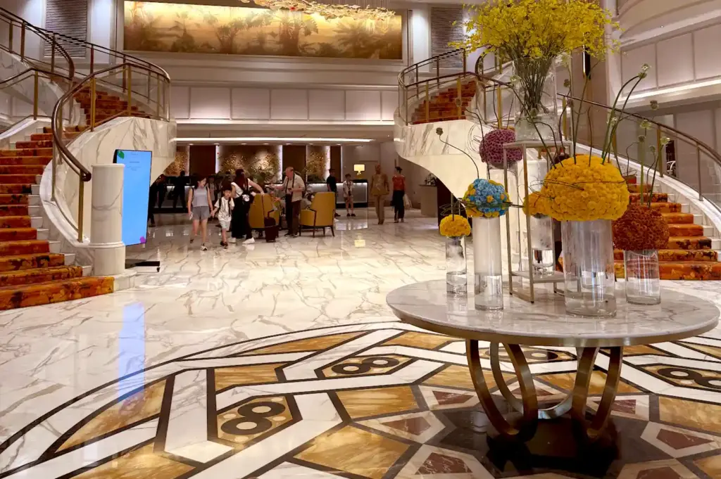 Grand marble hotel lobby and double staircase of Royal Plaza on Scotts leading guests to Carousel Buffet.